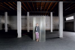 Szenografische Rauminszenierung von Elena Antoni in der Transbona-Halle in Basel mit transluzentem Raumteiler und zentral positionierter Person im minimalistischen Industrieambiente. elena antoni, innenarchitektur, szenografie, kreative beratung, basel, schweiz, deutschland