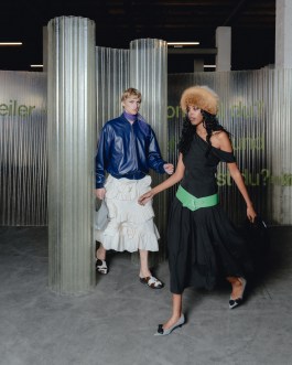 Szenografische Modeinszenierung von Elena Antoni in Basel mit zwei Models in expressiven Outfits vor transluzenten Raumteilern, Teil eines narrativen Raumkonzepts in industrieller Umgebung. elena antoni, innenarchitektur, szenografie, kreative beratung, basel, schweiz, deutschland